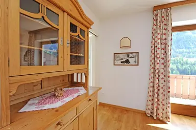 a kitchen with a wooden cabinet and a window at Apartments Valverda in Ortisei