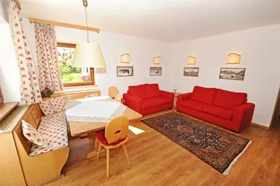 a living room with two red couches and a table at Apartments Valverda in Ortisei