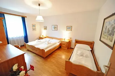 a hotel room with two beds and a window at Apartments Valverda in Ortisei