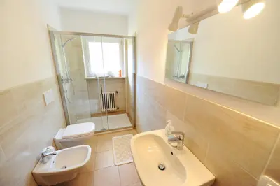 a bathroom with a sink and a toilet and a mirror at Apartments Valverda in Ortisei