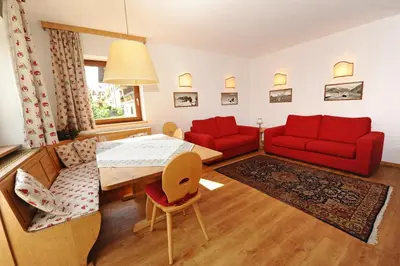 a living room with a red couch and a table at Apartments Valverda in Ortisei