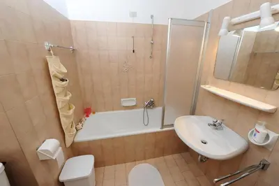 a bathroom with a tub and a sink and a toilet at Apartments Valverda in Ortisei