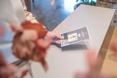 a person is holding a box on a counter at Hotel ANDER in Brunico