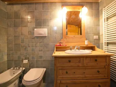 a bathroom with a sink and a toilet and a mirror at Typical Cottage in Bellamonte Italy with bubble bath in Bellamonte