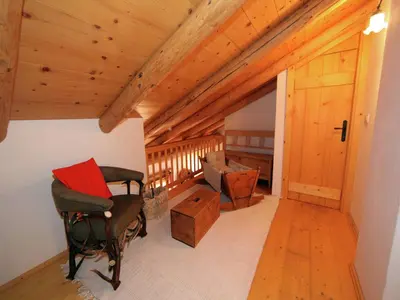 an attic room with a rocking chair and a wooden ceiling at Typical Cottage in Bellamonte Italy with bubble bath in Bellamonte