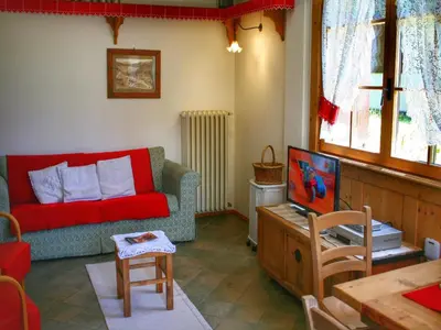a living room with a red couch and a tv at Typical Cottage in Bellamonte Italy with bubble bath in Bellamonte