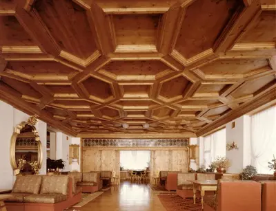 a large room with a wooden ceiling and furniture at Hotel Villa Argentina in Cortina dʼAmpezzo
