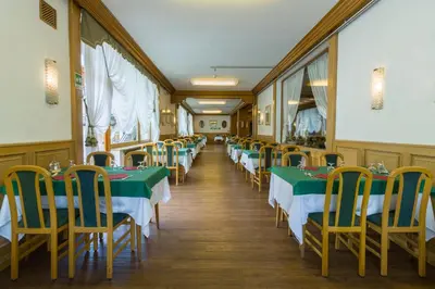 a row of tables and chairs in a restaurant at Hotel Villa Argentina in Cortina dʼAmpezzo