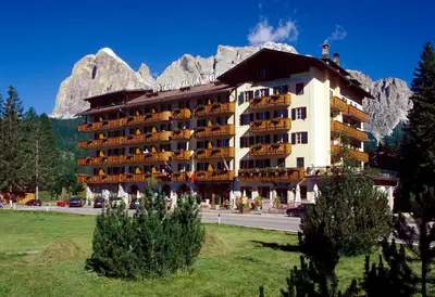a large hotel with a mountain in the background at Hotel Villa Argentina in Cortina dʼAmpezzo