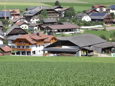 a small village with houses and a field of crops at Hölzlhof Apartments in Rasun di Sopra