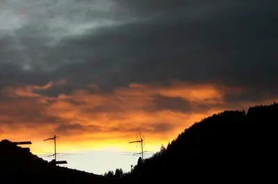 a sunset over a hill with a cloudy sky at Hölzlhof Apartments in Rasun di Sopra