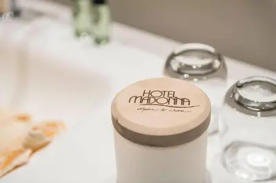 a wooden object on a sink with a hotel muthuth sign at Hotel Madonna in Castelrotto