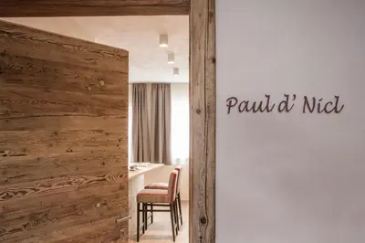 a room with a table and chairs and a wall with the words peanut niet at Osti Nicl in San Martino in Badia