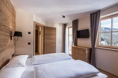 a bedroom with two beds and a window at Osti Nicl in San Martino in Badia
