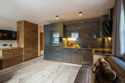 a kitchen with gray cabinets and a couch in a room at Osti Nicl in San Martino in Badia