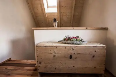a wooden chest in a room with a window at Osti Nicl in San Martino in Badia