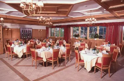 a dining room with tables and chairs and chandeliers at Gasthaus zum Weissen Kreuz in Lazfons