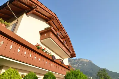 a balcony of a building with flowers on it at Gästehaus Thaler in Caldaro