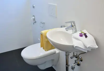 a white bathroom with a sink and a toilet at Cesa Setil in Ortisei