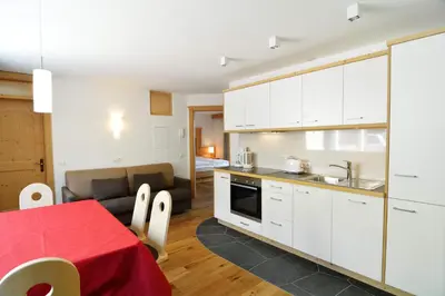 a kitchen and living room with a table and a couch at Cesa Setil in Ortisei
