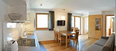 a kitchen and living room with a table and a couch at Cesa Setil in Ortisei