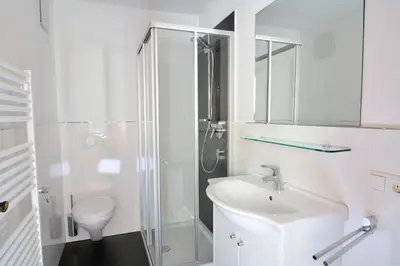 a white bathroom with a sink and a shower at Cesa Setil in Ortisei