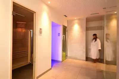 a woman in a white dress standing in a hallway at Hotel Tirolerhof in Terento