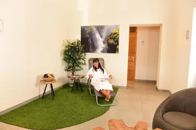 a man sitting in a chair in a room with a painting at Hotel Tirolerhof in Terento