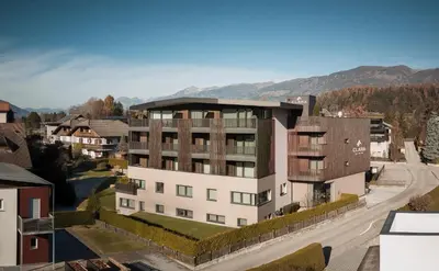 a building in the snow with a snow covered tree at B&B Boutiquehotel Clara in Brunico