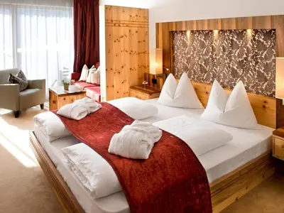 a bedroom with a large bed with towels on it at Bella Vista Hotel Emma in San Vigilio Di Marebbe