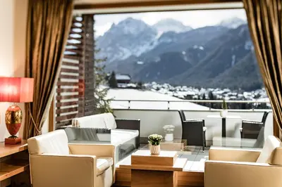 a living room with a view of a mountain at Bella Vista Hotel Emma in San Vigilio Di Marebbe