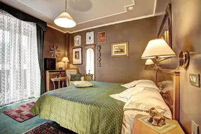 a bedroom with a bed with a teddy bear on a table at Hotel Regina in San Martino di Castrozza
