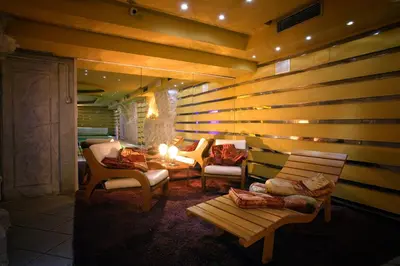 a room with a wooden wall with chairs and a table at Hotel Regina in San Martino di Castrozza