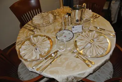 a table with plates and glasses and silverware on it at Hotel Regina in San Martino di Castrozza