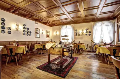 an empty dining room with tables and chairs at Hotel Regina in San Martino di Castrozza
