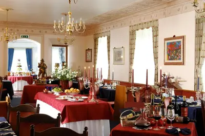 a dining room with tables with red table cloth at Hotel Regina in San Martino di Castrozza