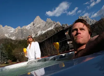 a man and a woman standing next to a swimming pool at Hotel Regina in San Martino di Castrozza