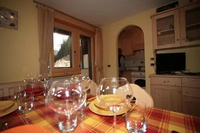 a dining room table with wine glasses on it at Appartamenti Cercenà Deluxe in Canazei