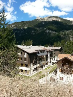 an apartment building with a mountain in the background at Appartamenti Cercenà Deluxe in Canazei