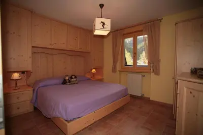 a bedroom with a bed with two teddy bears on it at Appartamenti Cercenà Deluxe in Canazei