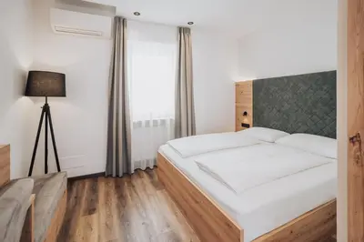 a bedroom with a bed and a lamp at Feichter Hotel & Living in Bolzano