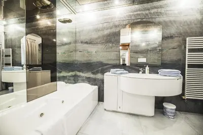a bathroom with a white sink and a tub and a bath tub at Apartments Villa Venezia Luxury in Ortisei