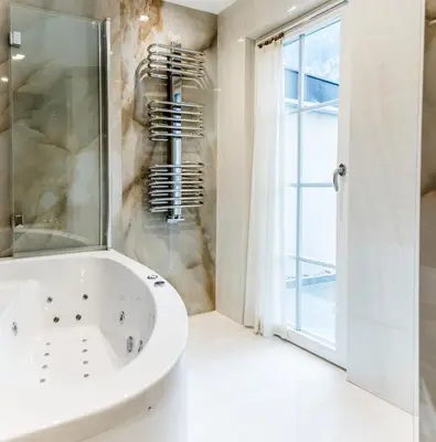 a white bathroom with a tub and a window at Apartments Villa Venezia Luxury in Ortisei