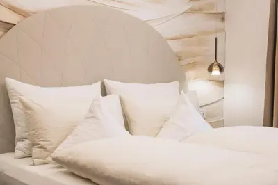 a white bed with white pillows in a room at Apartments Villa Venezia Luxury in Ortisei