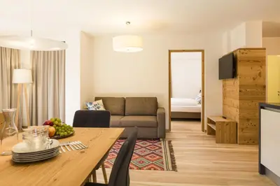 a living room with a table and a couch at Residence Luzerna *** in Selva di Val Gardena