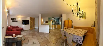 a kitchen and living room with a table and a dining room at Casa Fam.Barbolini in Tesero