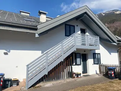 a white house with a balcony with blue shutters at Casa Fam.Barbolini in Tesero
