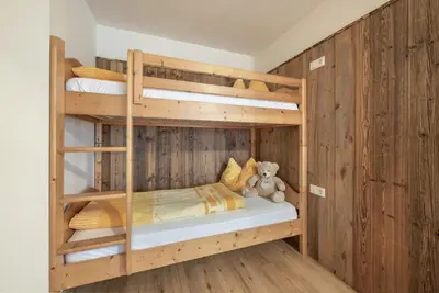 a bedroom with bunk beds with a teddy bear at Bergdiamant in Maranza