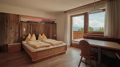 a bedroom with a bed and a desk and a window at Bergdiamant in Maranza