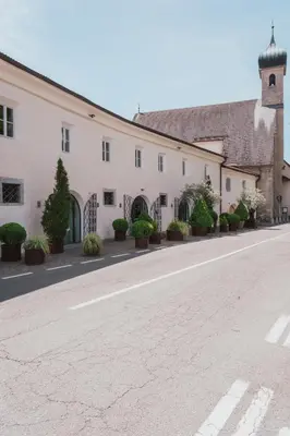 an empty street in front of a white building at Residence Traube in Bressanone